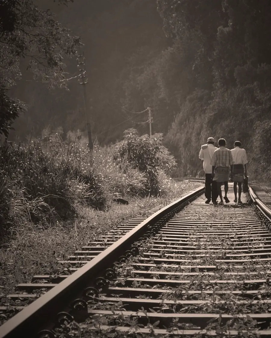 Travellers walking along a hill-country railway in Sri Lanka
